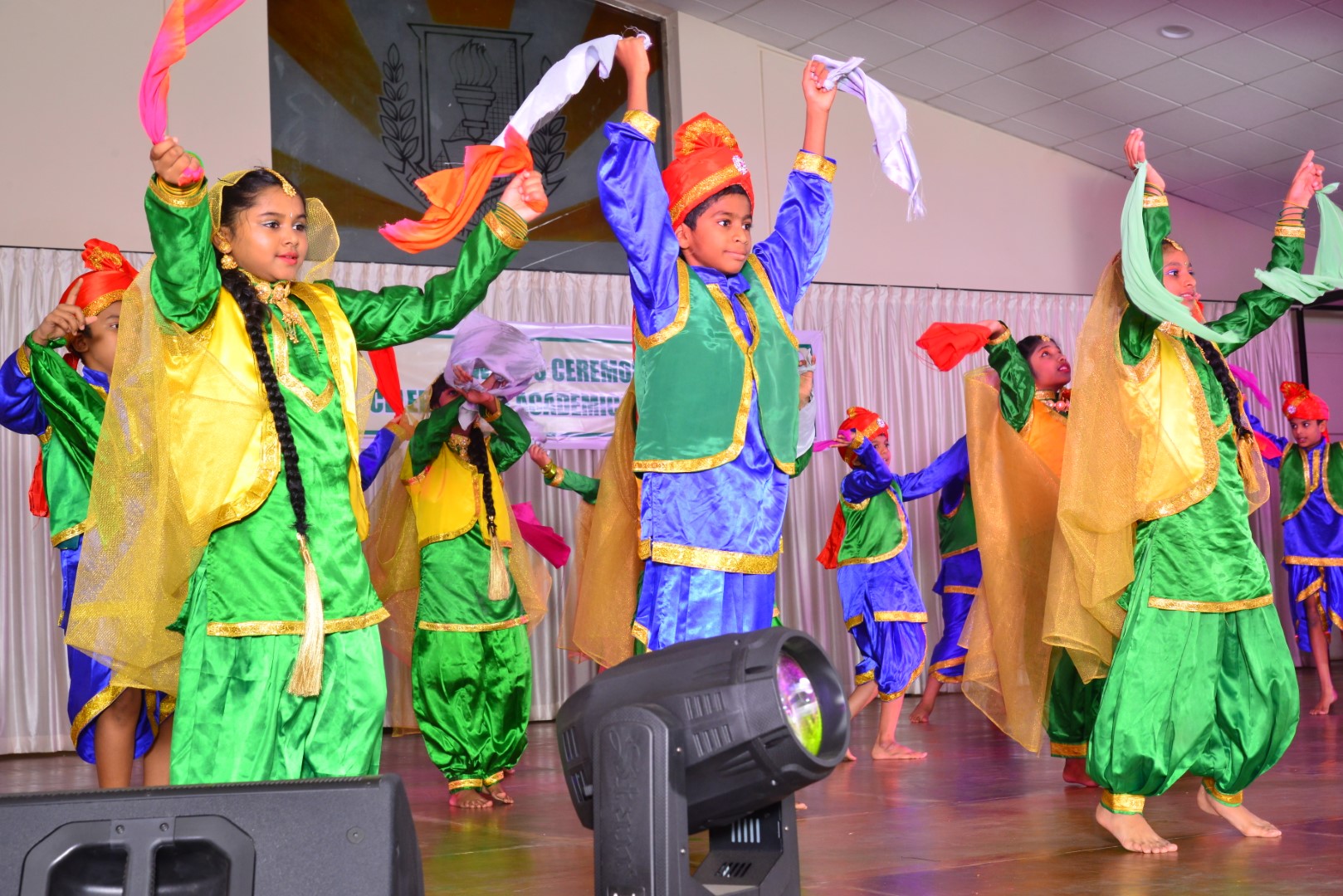 A group of students dressed in colorful attire, energetically performing Bhangra dance with joy and enthusiasm.